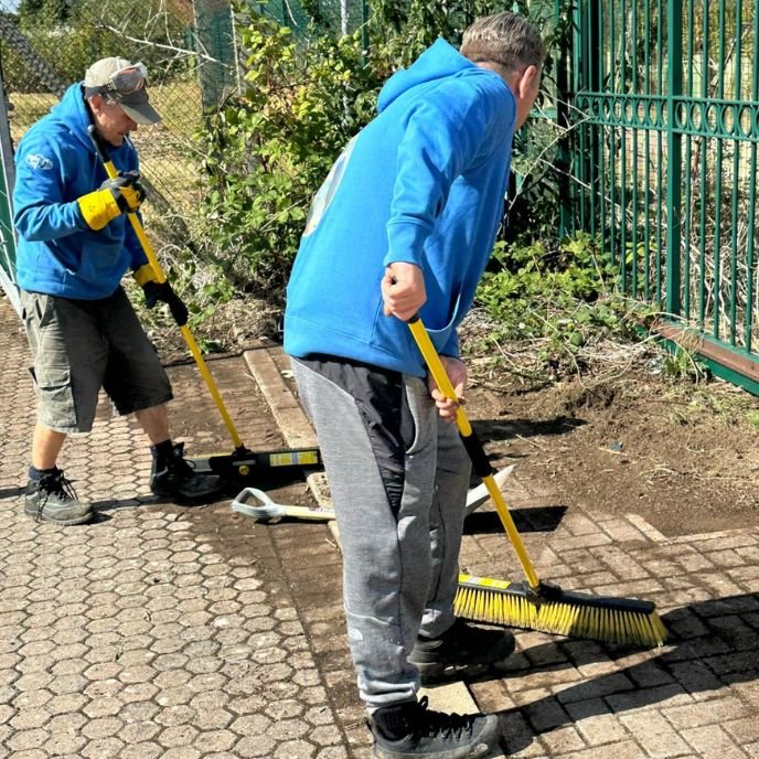 Volunteers sweeping a path