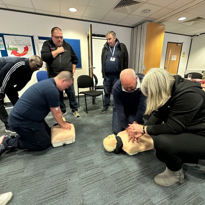 Participants practising CPR on training manikins